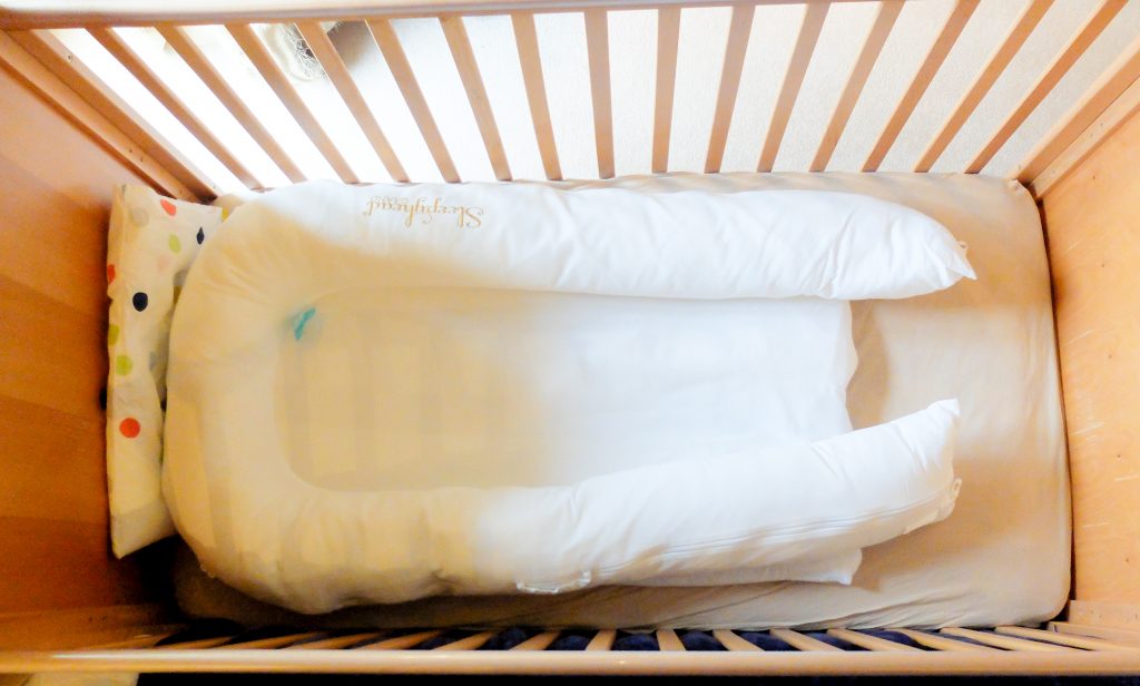 The Sleepyhead Grand in a cot, featured in a review as part of my travel tips series on Mini Travellers