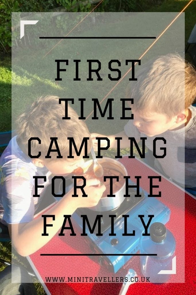 two boys cooking outside while camping with the words 'First Time Camping For The Family'
