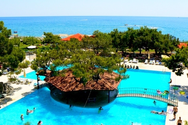 View of Luxury hotel with hut, swimming pool and beach in Turkey.